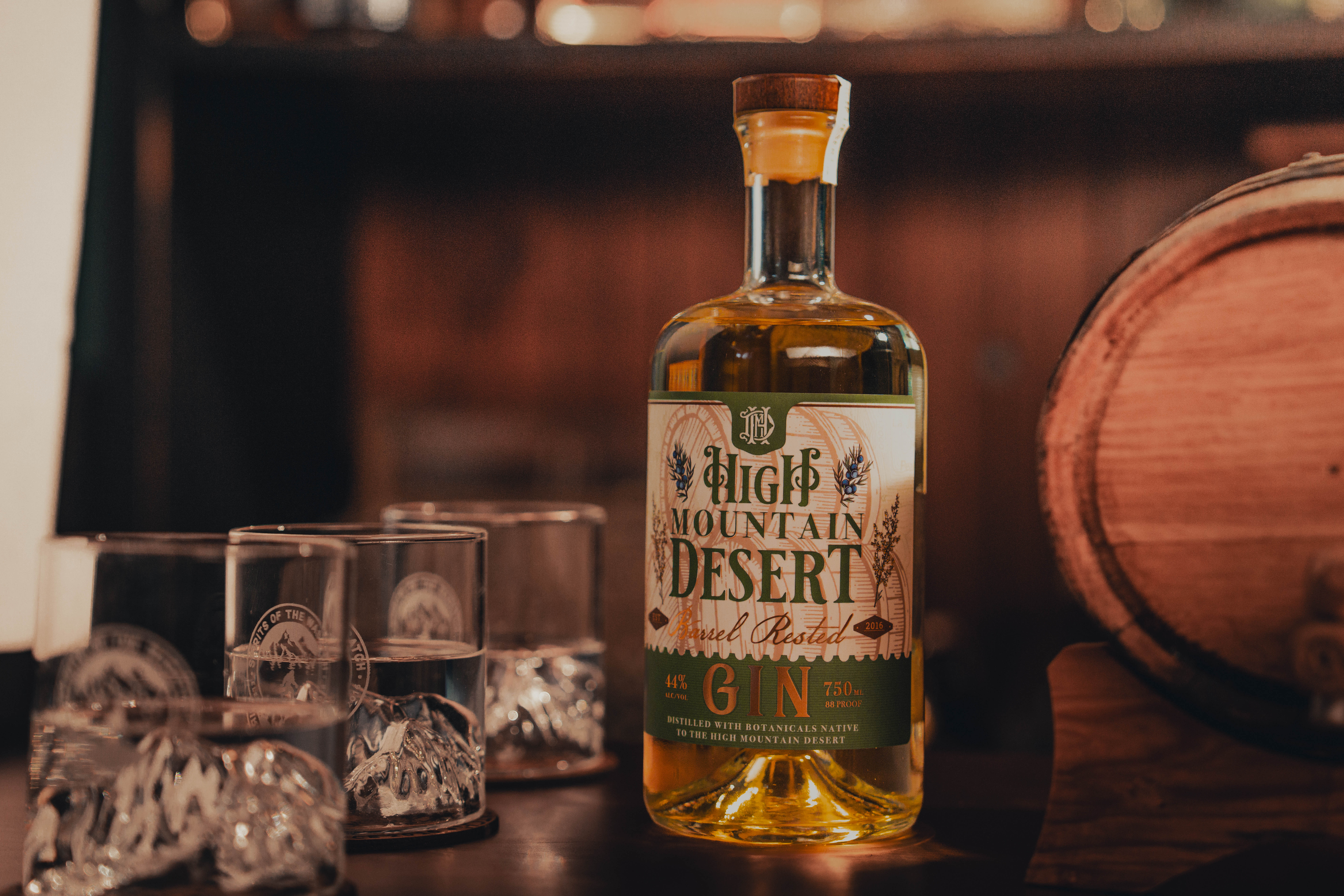 High Mountain Desert Gin: Barrel Rested Bottle - Professionally photographed. Sitting atop an aging barrel.