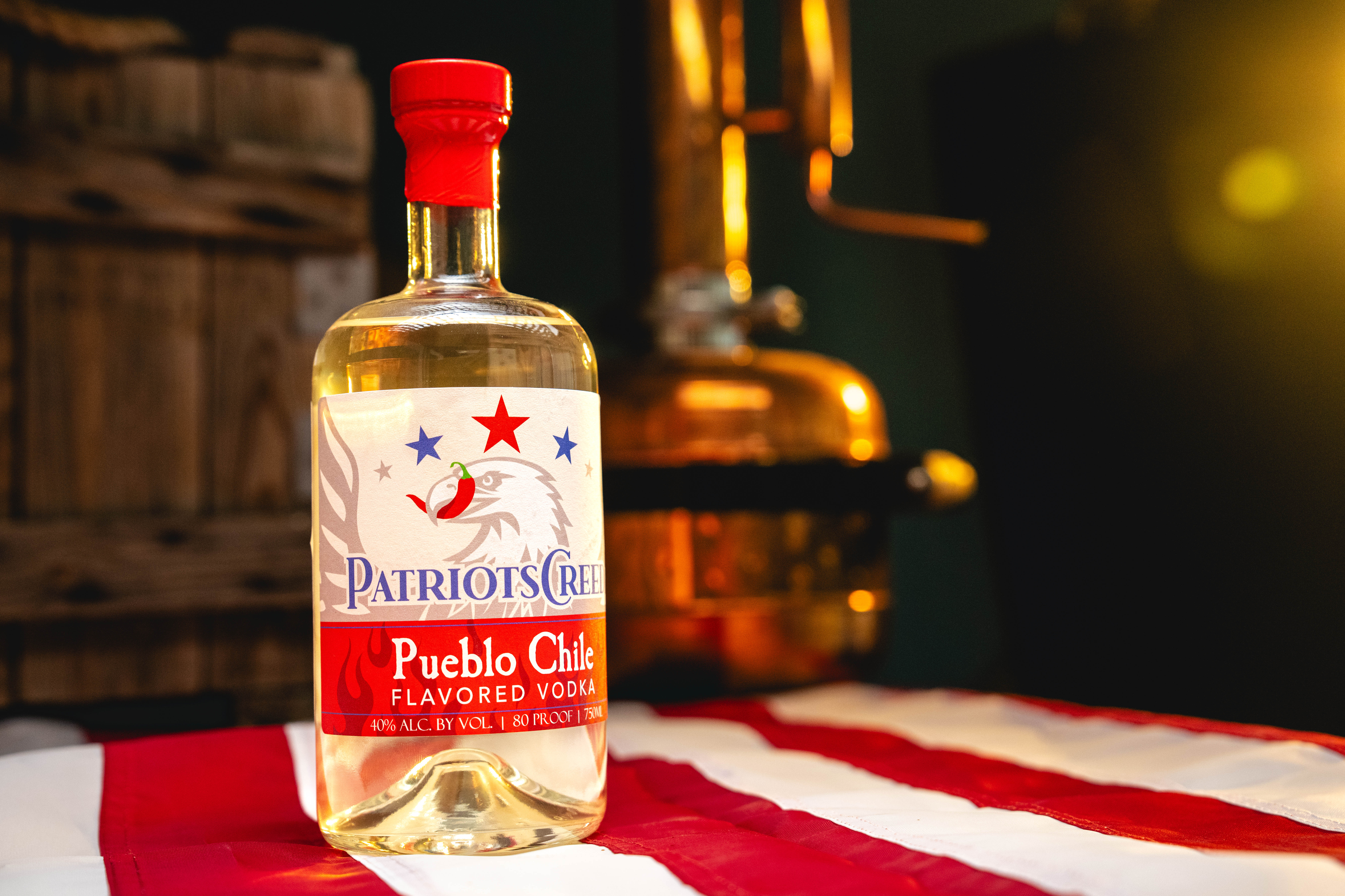 Patriot's Creed Vodka: Pueblo Chile Bottle - Professionally photographed. Sitting atop an American flag.